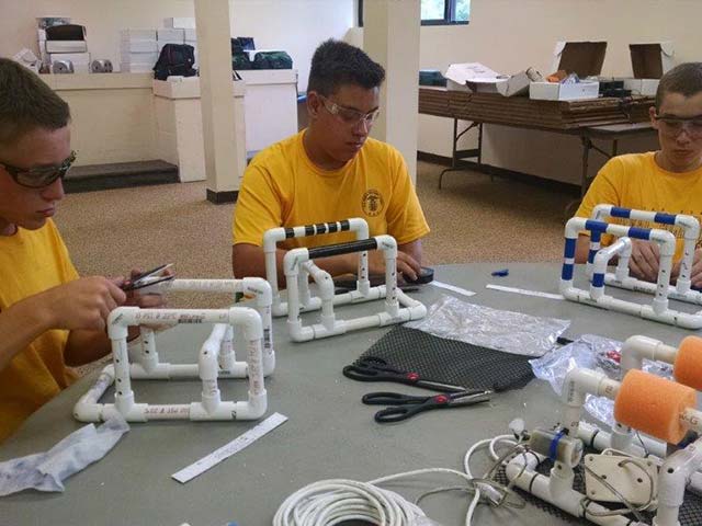 Hiram House campers building a project from PVC pipe