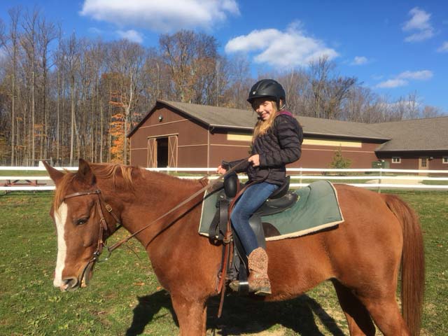 Student riding horse at Hiram House Camp
