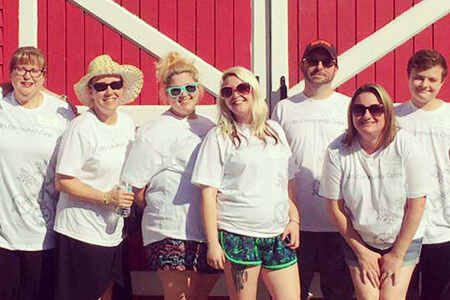 Adults standing in front of red barn