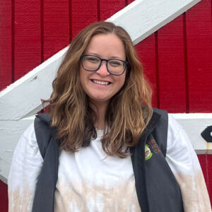 Portrait of Grace Juergens in front of a red barn door